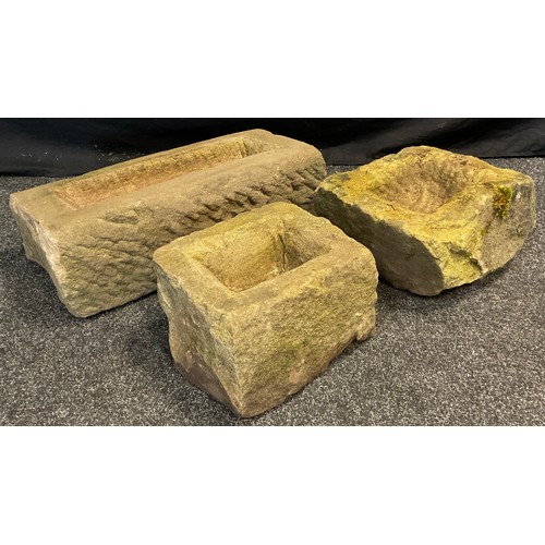 97 - Three rough hewn Derbyshire Gritstone troughs, of graduated sizes, the largest measuring 18 cm high ... 