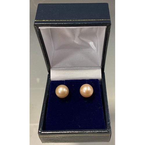 447 - A pair of pale pink cultured pearl stud earrings, 9ct gold fittings, 2.5g gross, boxed