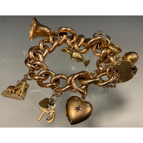 453 - A 9ct gold fancy link charm bracelet, suspending seven gold and gold plated charms, 9ct gold padlock... 