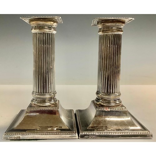 52 - A pair of silver candlesticks, fluted columns, 13.5cm high, Sheffield 1925