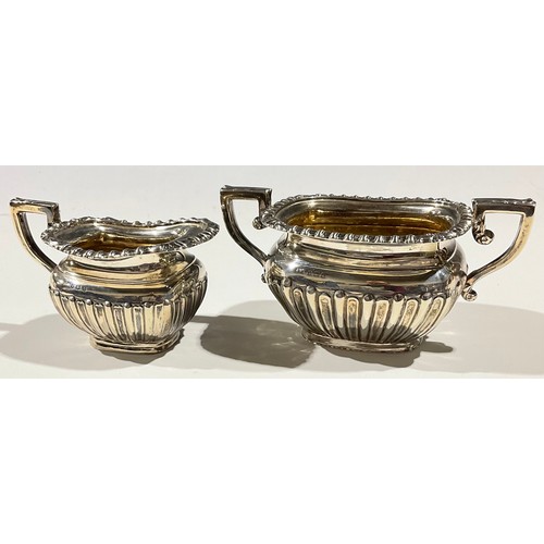 61 - A matched late Edwardian/George V silver milk jug and sugar bowl, boat shaped, stop fluted, the inte... 