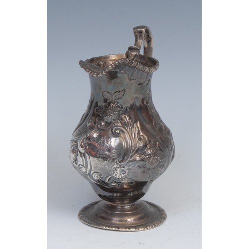 65 - An 18th century silver baluster cream jug, wrythen fluted and chased with flowers and foliage, gadro... 