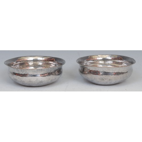 69 - A pair of Continental silver coloured metal circular dishes, each chased with bands of scrolls and s... 