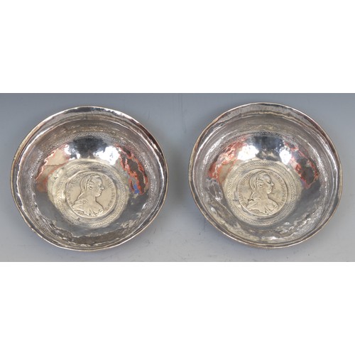 69 - A pair of Continental silver coloured metal circular dishes, each chased with bands of scrolls and s... 