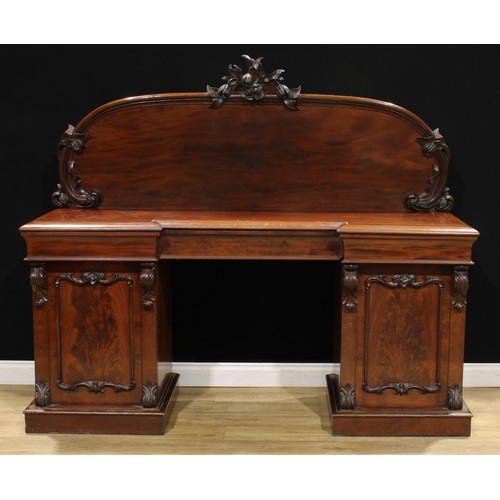 116 - A Victorian mahogany twin pedestal sideboard, arched mirror back with carved cresting, the projectin... 