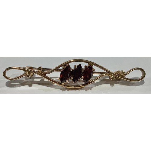 674 - A 9ct gold bar brooch, set with three faceted oval garnets, 4.75cm wide, marked 375, 3.4g