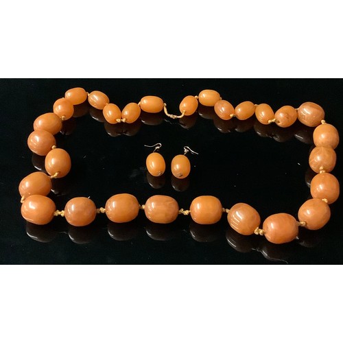 681 - A single strand of twenty eight butterscotch amber polished oval graduated beads, the largest 3cm, t... 