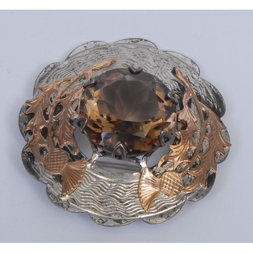 703 - A Scottish silver and gold coloured metal shaped circular plaid brooch, applied with thistles and ce... 