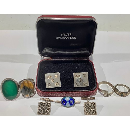 724 - Two pairs of silver cufflinks; four silver rings; a brooch