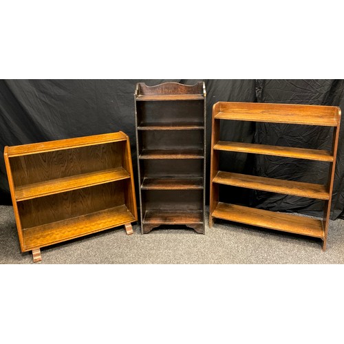 27 - A Mid 20th century dark oak open bookcase, of narrow proportions, shaped three-quarter galleried top... 
