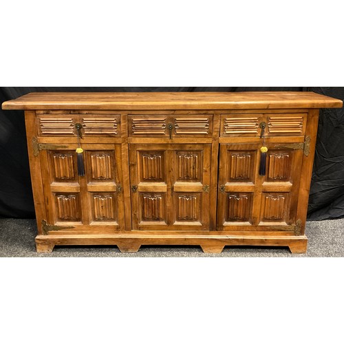 37 - A contemporary walnut sideboard, three short drawers to frieze, above three cupboard doors, carved l... 