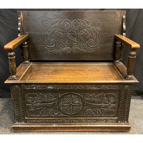 76 - An early 20th century carved oak Monk’s bench, 102cm (81.5cm) high x 106.5cm wide x 47cm deep.