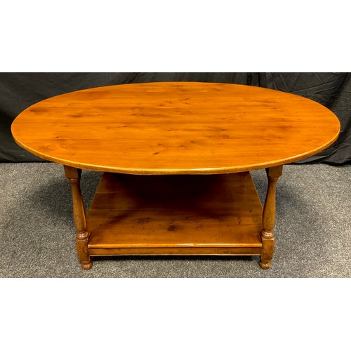 83 - A 20th century oval yew coffee table, shelf under tier, turned supports, 53cm high, 120cm long, 83cm... 