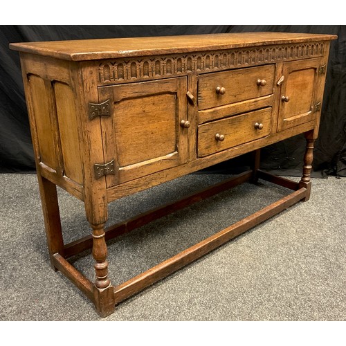 91 - A Titchmarsh and Goodwin style oak dresser base, the over-sailing rectangular top above a fluted fri... 