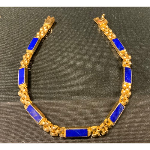 431 - A lapis lazuli mounted yellow metal fancy link bracelet, indistinct marks possibly Egyptian, 14.2g g... 