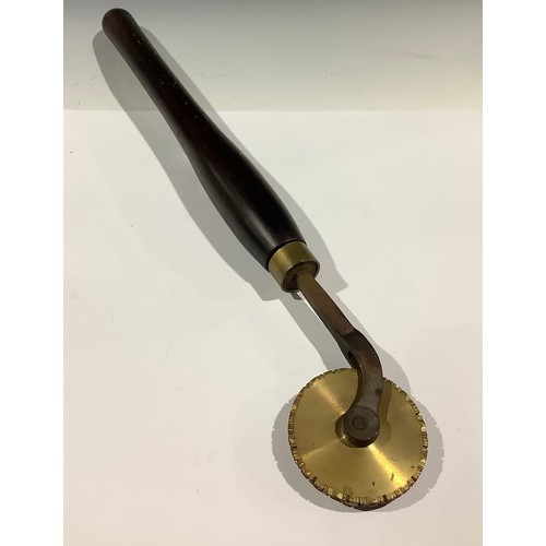 304 - Tools - a bookbinder’s finishing tool, decorative brass roll with wooden handle, 56cm