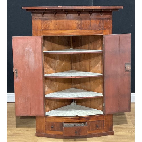 115A - A large George III mahogany bowfront corner cupboard, 131.5cm high, 96cm wide, 56cm deep