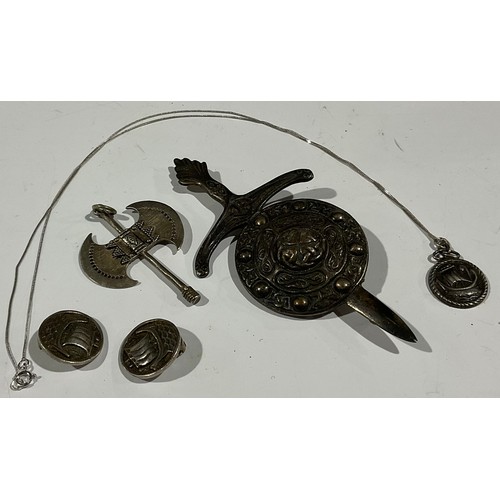 452 - An Arts and Crafts silver pendant and earrings; a large dagger and shield silver brooch; an axe pend... 