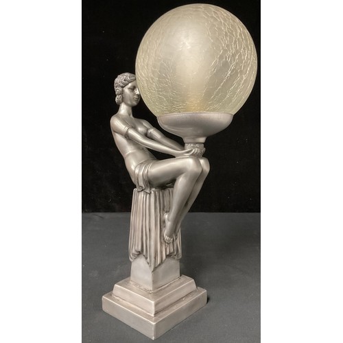 569 - An Art Deco style table lamp, moulded as a semi-clad female nude, seated with globe, crackle glass s... 