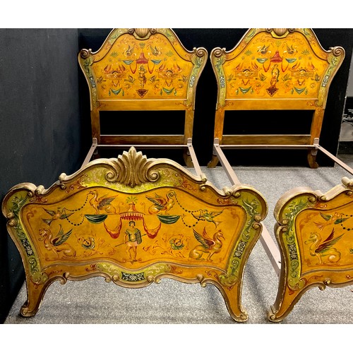 43 - A pair of carved and painted Venetian style single beds, the headboards with carved scallop cresting... 