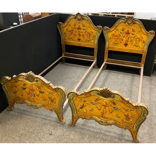 43 - A pair of carved and painted Venetian style single beds, the headboards with carved scallop cresting... 