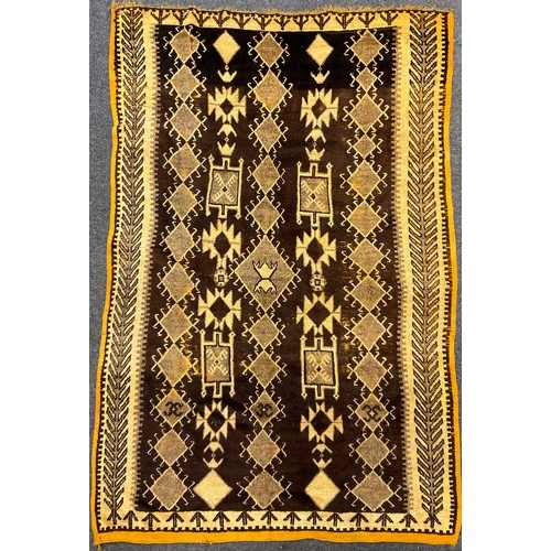 48 - A North African hand-knotted rug, in tones of brown and cream, narrow ochre yellow coloured margin, ... 