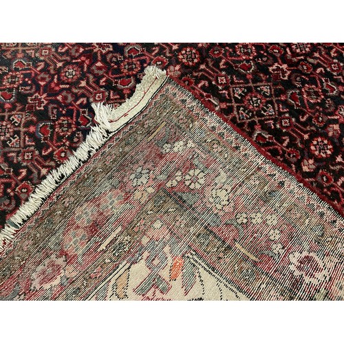 87 - A Persian Bidjar rug, hand-knotted with a central diamond-shaped medallion with stylised flowers, wi... 