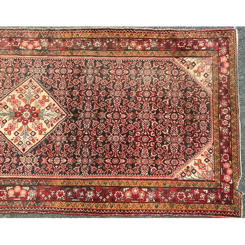 87 - A Persian Bidjar rug, hand-knotted with a central diamond-shaped medallion with stylised flowers, wi... 