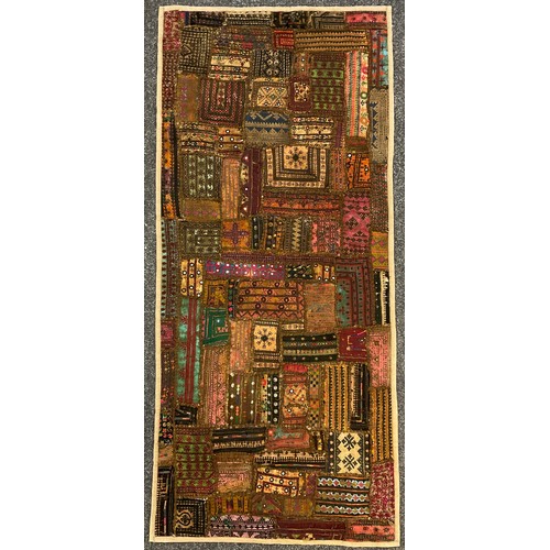 89 - A Moroccan Kuba throw / rug, hand-stitched and dyed fabric panels, with rows of abstract designs in ... 