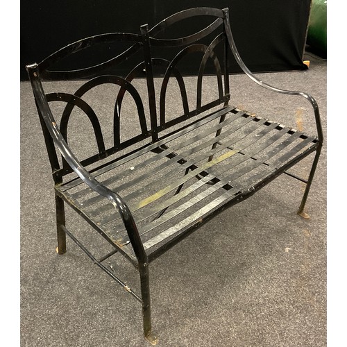 108 - An early to mid 20th century iron strapwork garden bench, arched back, slat strap seat, painted blac... 