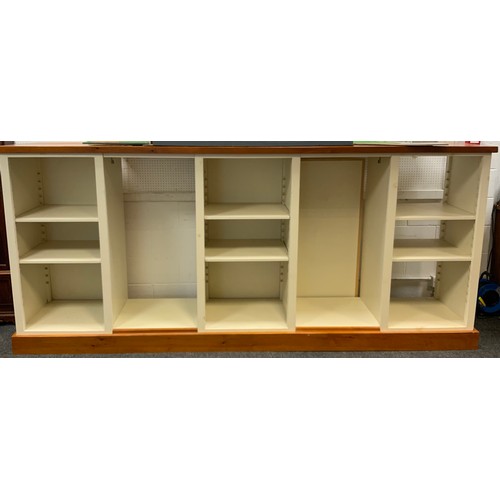 135 - A shop fitting display unit,  pine top and plinth, with five shelf or hanging rail compartments, hoo... 