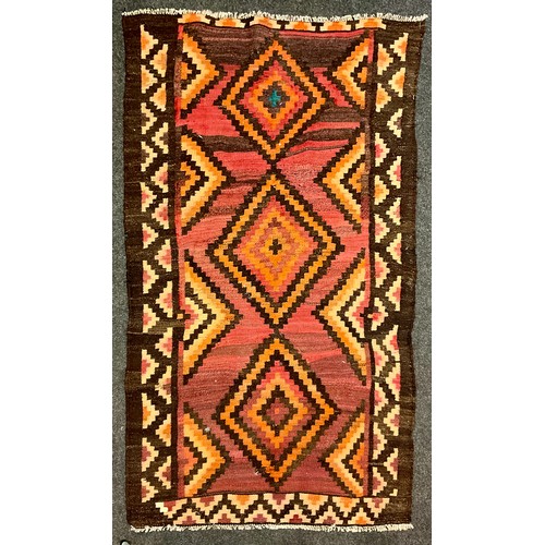 155 - A Qashgai Kilim rug, in tones of oranges, browns and pink 210cm x 115cm.