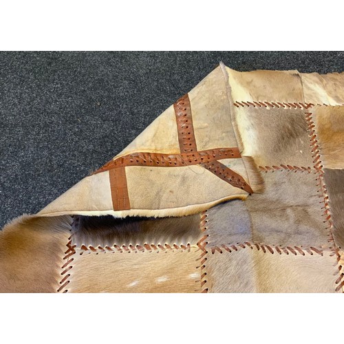 309 - A patchwork cow hide rug/tapestry, leather bound, 87cm x 153cm