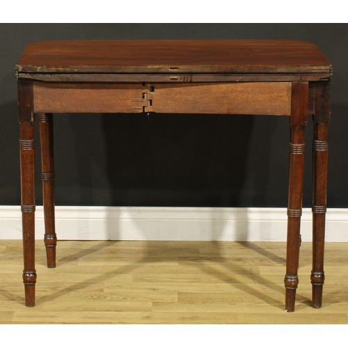 1253 - A 19th century mahogany tea table, hinged top with reeded edge above a deep frieze, ring-turned legs... 