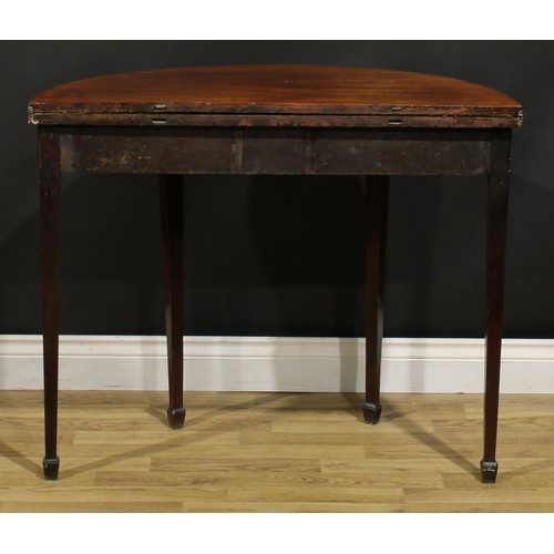 1308 - A George III mahogany demilune card table, hinged top with moulded edge enclosing a baize lined play... 