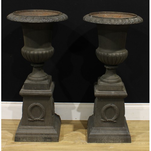 1517 - A pair of 19th century style cast iron fluted campana garden urns, each with an egg-and-dart rim, th... 