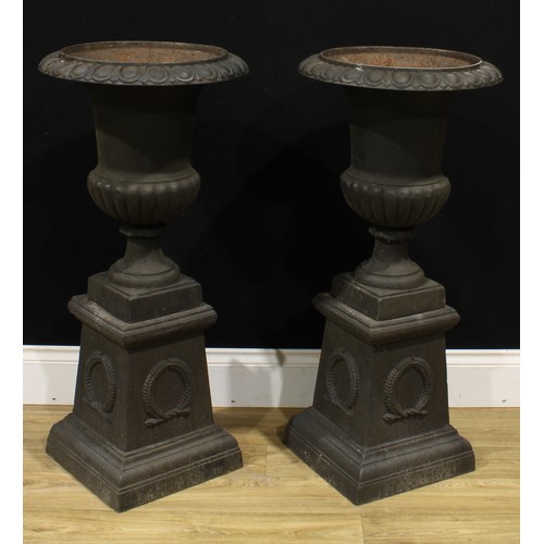 1517 - A pair of 19th century style cast iron fluted campana garden urns, each with an egg-and-dart rim, th... 