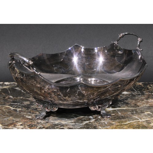 621 - A George V silver two-handled oval dish, in the Art Nouveau manner, shaped rim, four sinuous pad fee... 