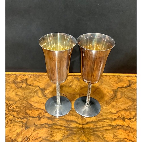 664 - A pair of Elizabeth II silver wine goblets, plain bell shaped bowls, gilt lined interior, textured s... 