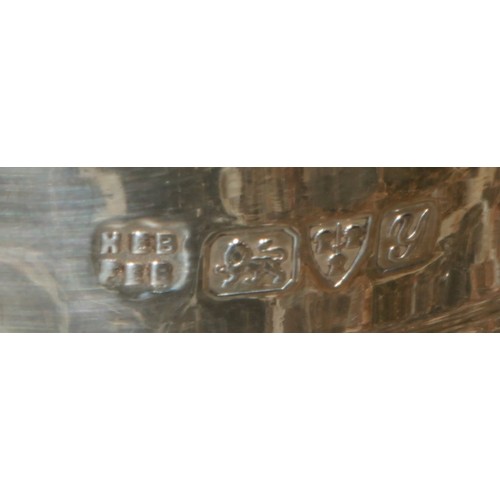 607 - A George V silver cup, in the Arts and Crafts manner, planished with plain border decorated with cir... 