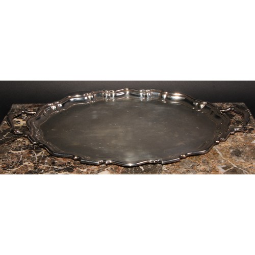 693 - A silver two-handled shaped oval tray, piecrust border, plain field, 54cm over handles, William Suck... 