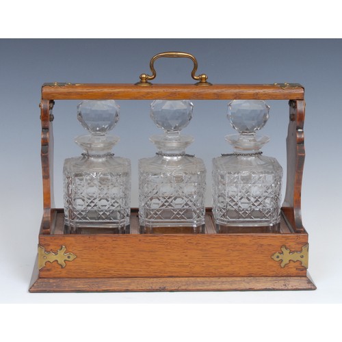 2193 - A Victorian brass mounted oak three bottle tantalus, brass plaque to front inscribed 'The Cabinet' R... 