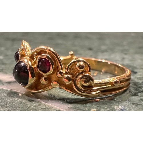 926 - An 18ct gold garnet ring, set with three circular cabochon red garnets, shaped scrolling crest, 18ct... 