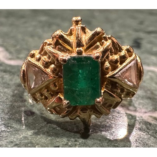 934 - An emerald and diamond ring, rectangular emerald cut emerald approx 0.60ct, within ornate shield cre... 