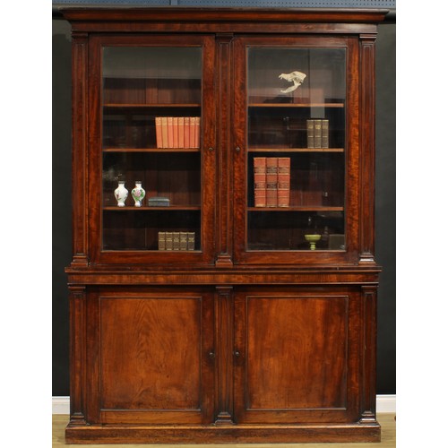 1548 - A Post-Regency mahogany library bookcase, outswept cornice above a pair of glazed doors enclosing ad... 