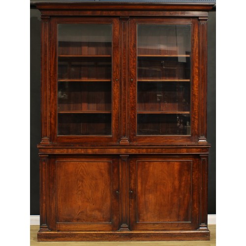 1548 - A Post-Regency mahogany library bookcase, outswept cornice above a pair of glazed doors enclosing ad... 