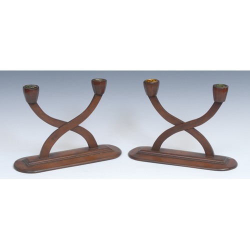 2177 - A pair of Secessionist mahogany two-light table candelabra, curved X-shaped branches, stepped socles... 