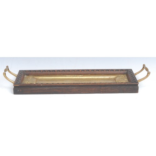 2206 - An Arts and Crafts oak and brass rectangular two-handled serving tray, the planished field chased wi... 