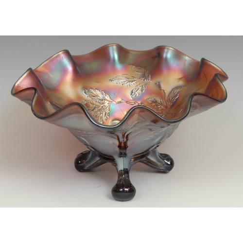 67 - A carnival amethyst glass shaped circular bowl, moulded in low relief with a peacock and leafy folia... 