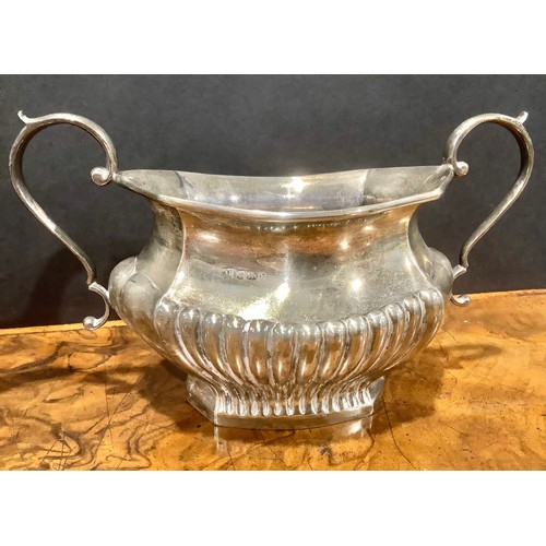 776 - An Edwardian silver half fluted three piece tea service, comprising teapot, sugar basin and cream ju... 